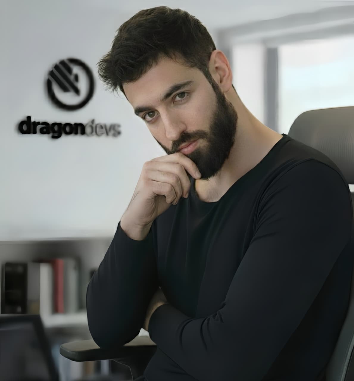 Salman Khan (skdrh), founder of dragondevs, seated in front of the dragondevs logo